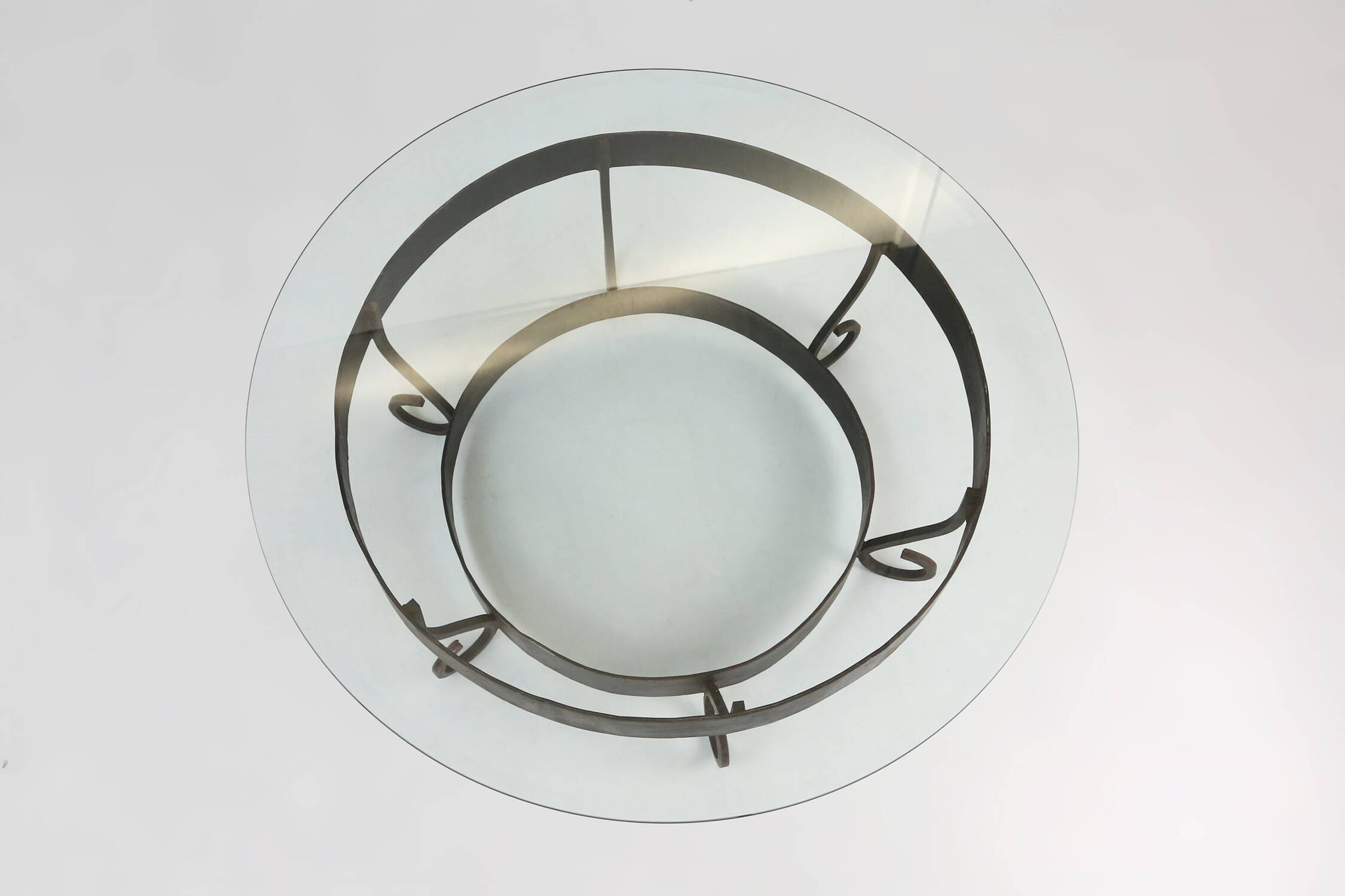 Rustic round coffee table with wrought iron base and glass top, France, 1930s