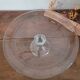 Large glass display plate mounted on a stand.