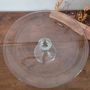 Large glass display plate mounted on a stand.