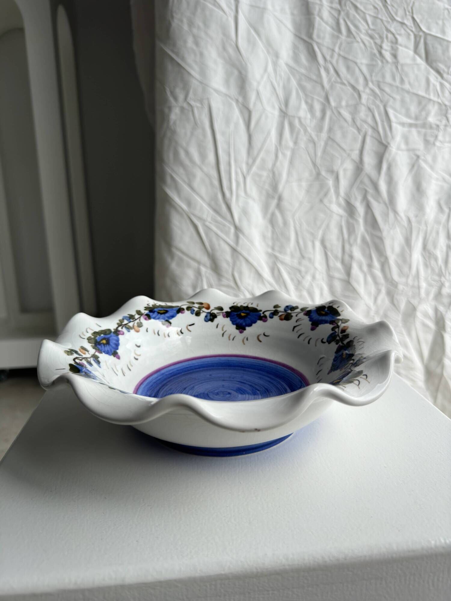 Small hand-painted earthenware salad bowl with garland of blue flowers, mark below
