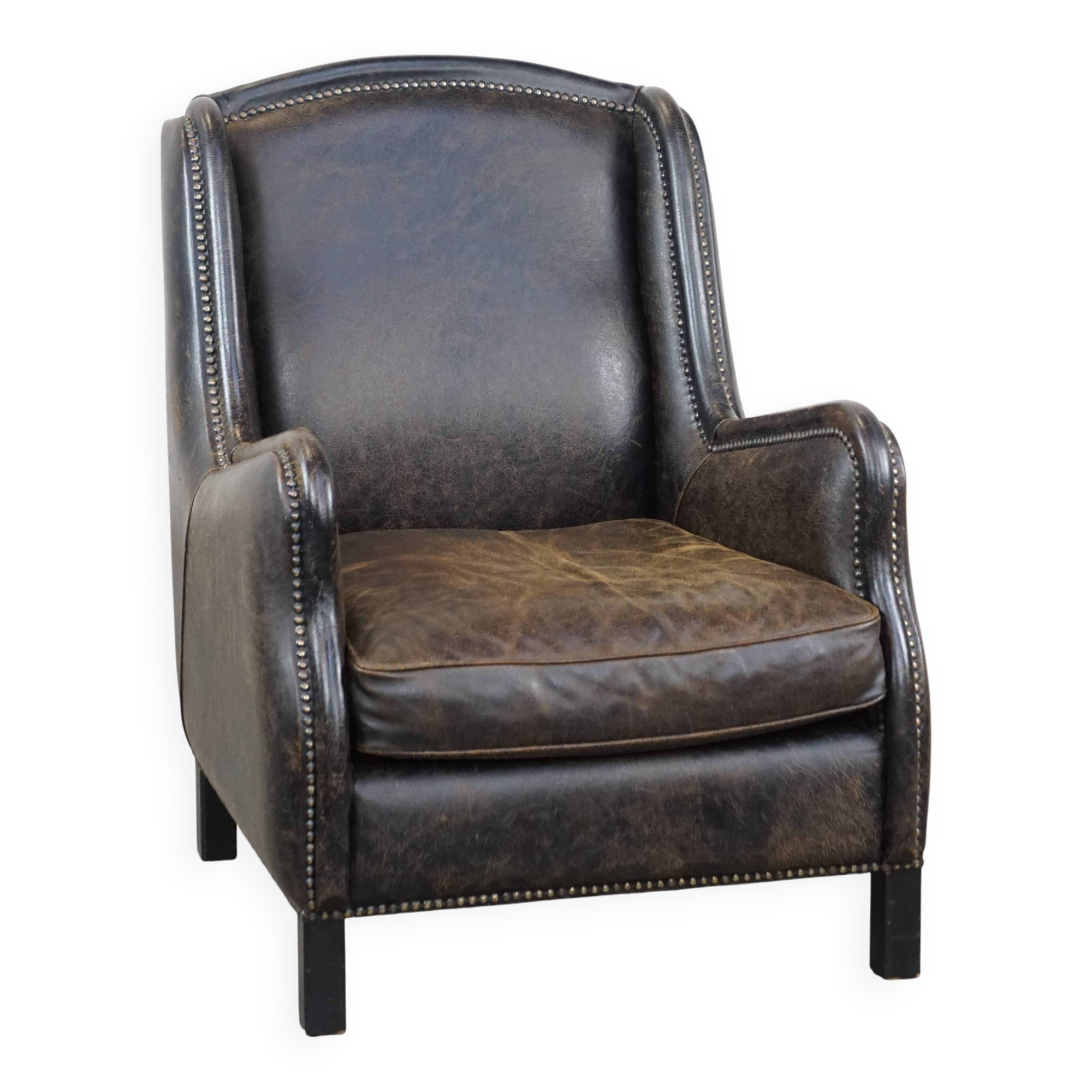 Black cow leather armchair finished with decorative nails, industrial style