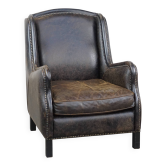 Black cow leather armchair finished with decorative nails, industrial style