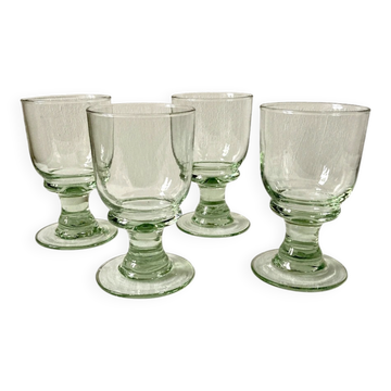 4 stemmed glasses made of handcrafted blown glass in green hue.