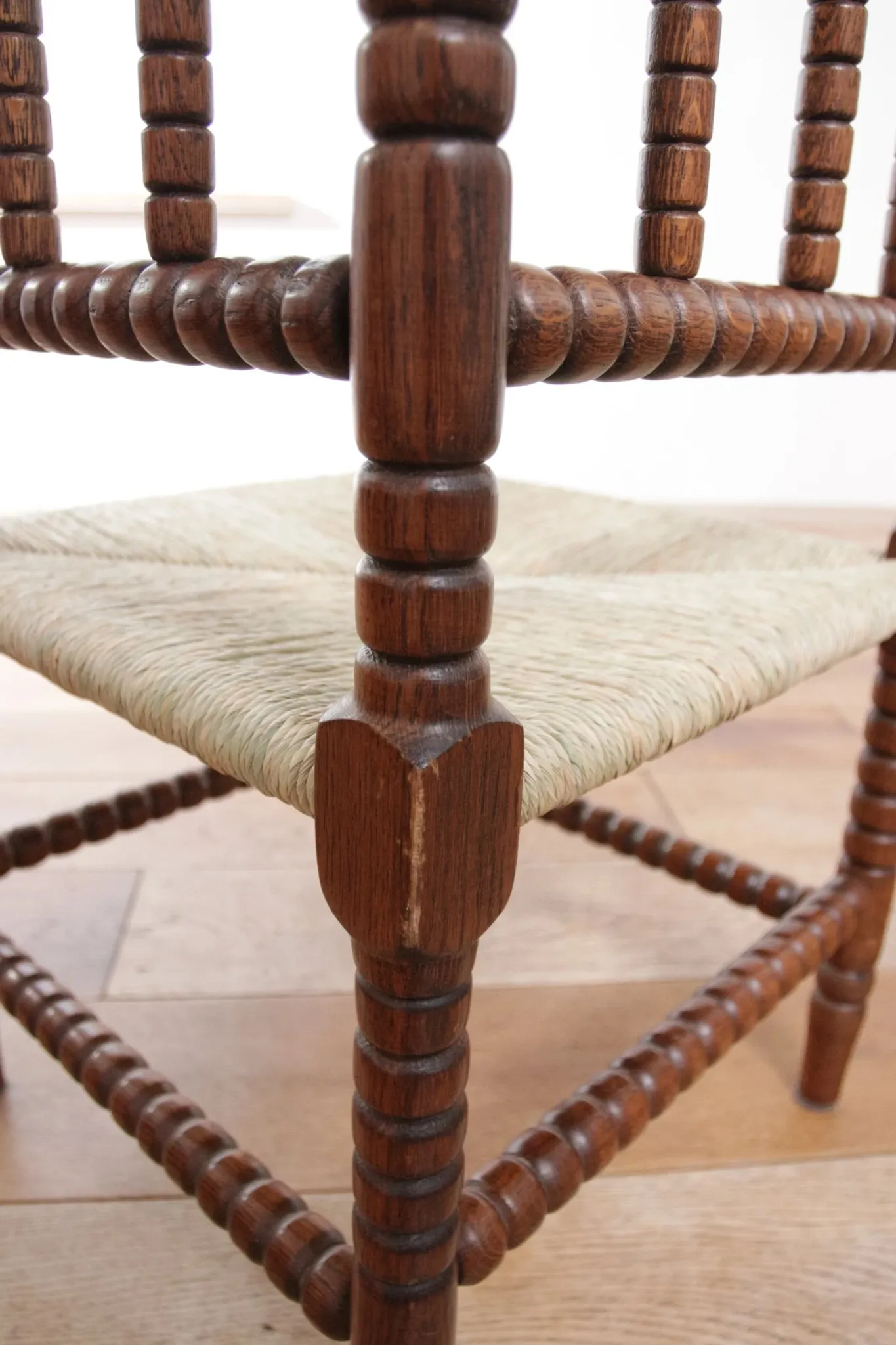 Antique Dutch oak corner chair with turned spindles and new rush seat
