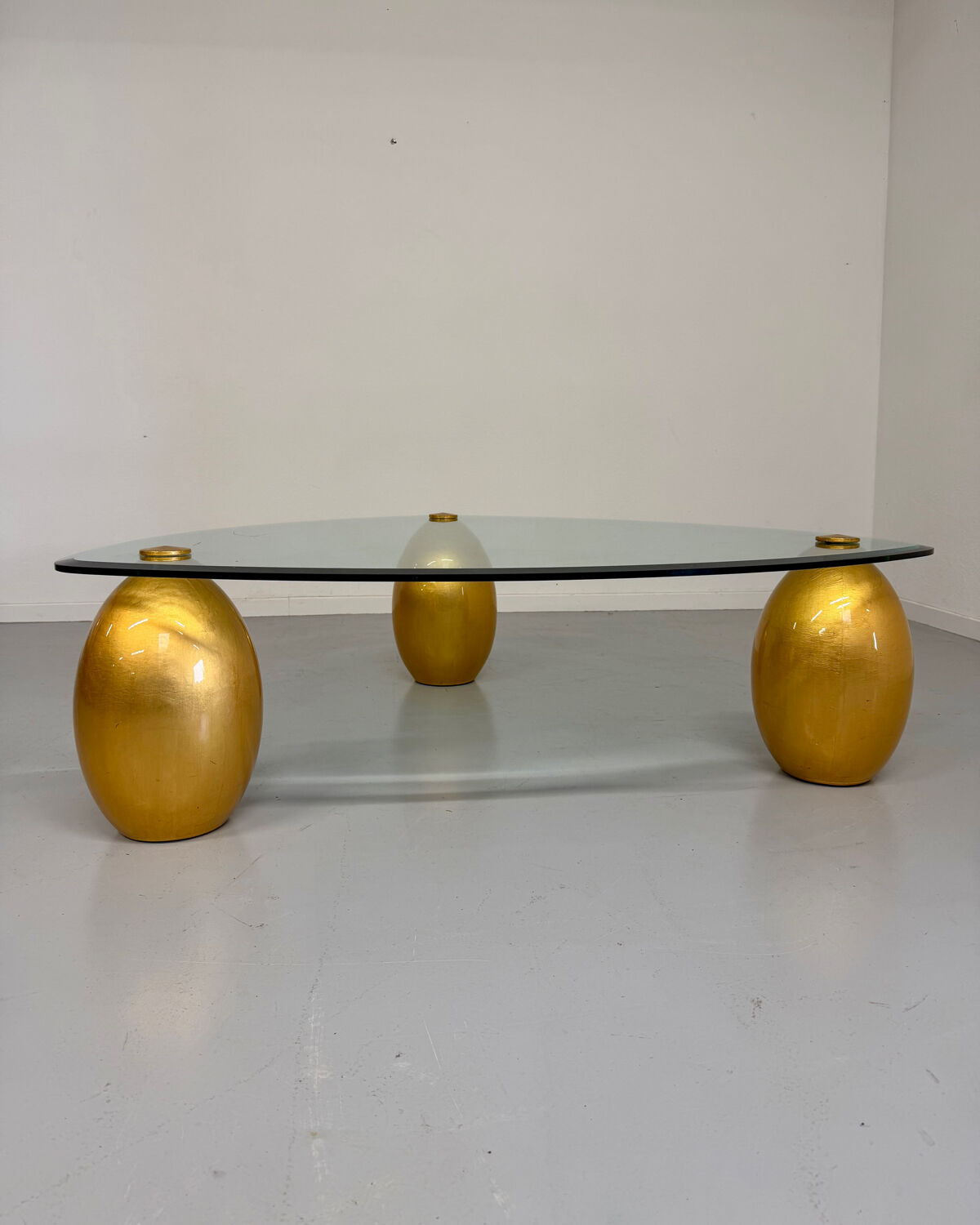 Vintage Italian design coffee table with a glass top and gold base, dating from the 1980s.