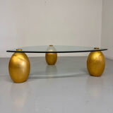 Vintage Italian design coffee table with a glass top and gold base, dating from the 1980s.