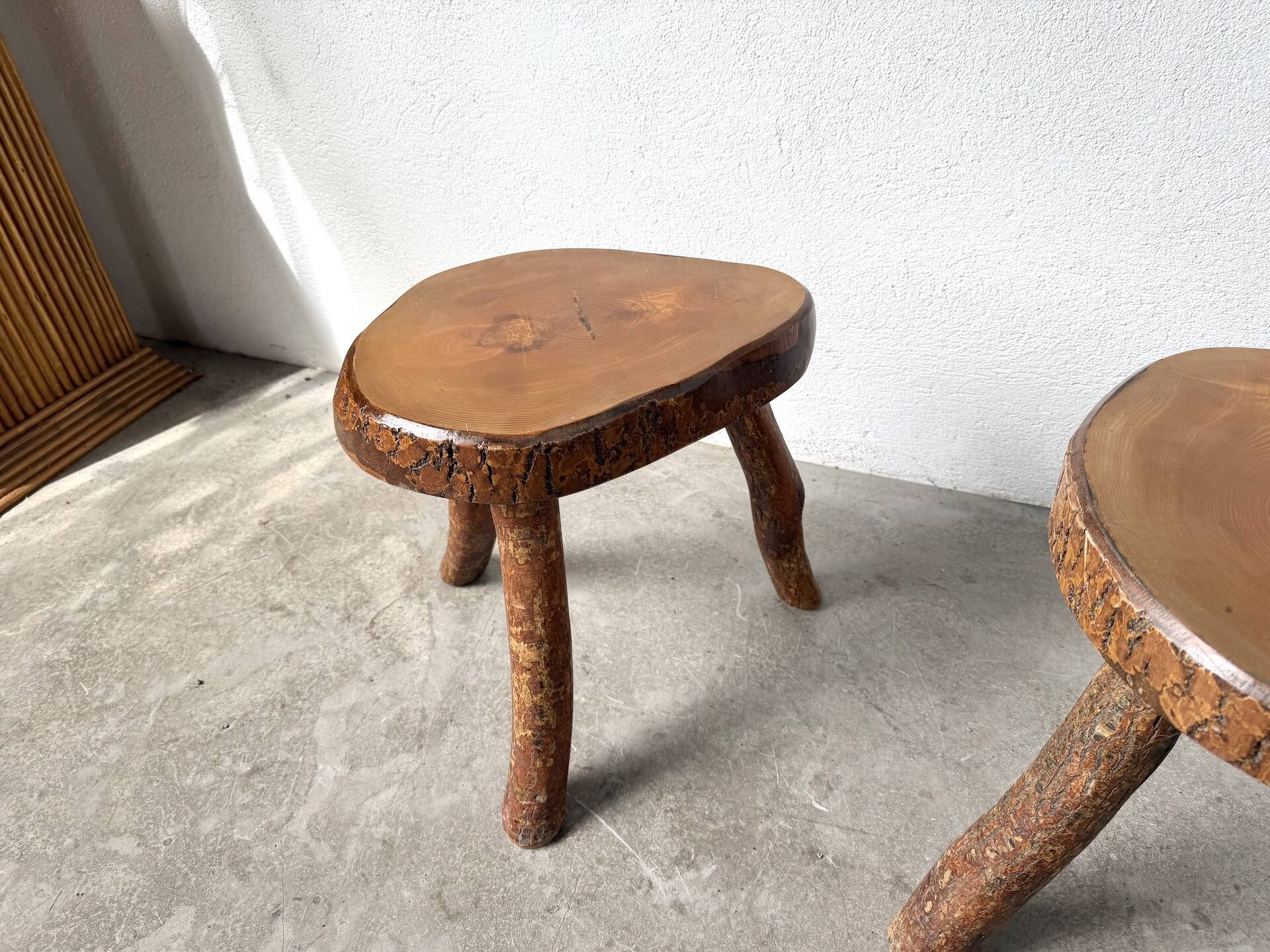 Set of three rustic solid wood tripod stools.