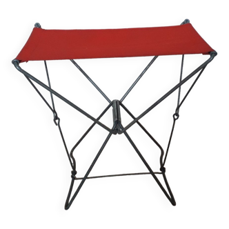 Tabouret pliant en toile rouge mais décousu sur un des côtés