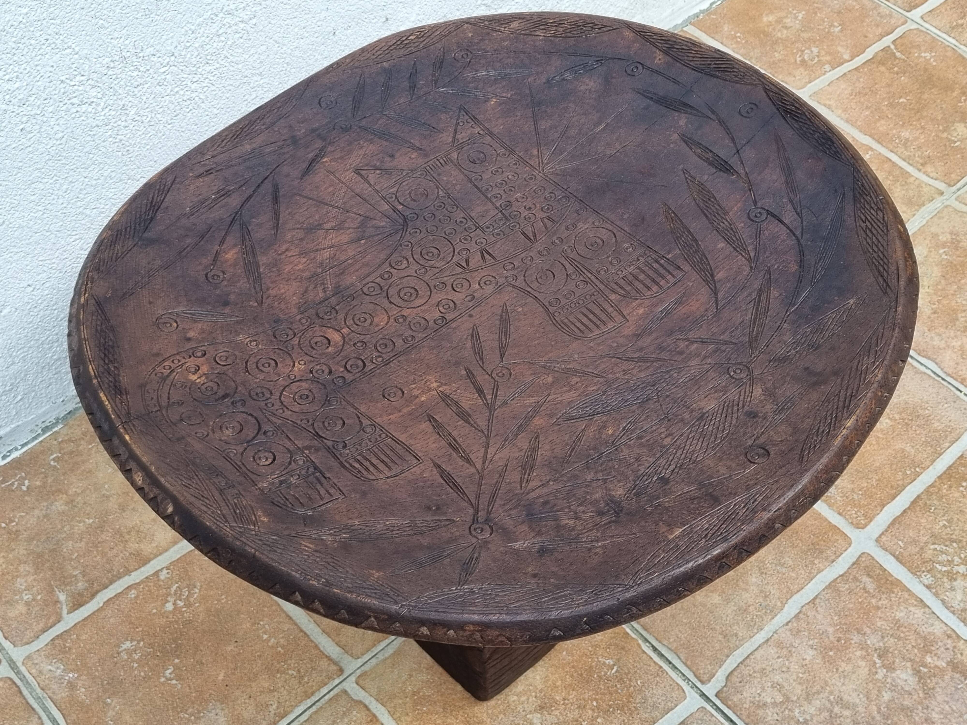 African monoxyle side table in carved wood with a curved top, 48x36 cm.