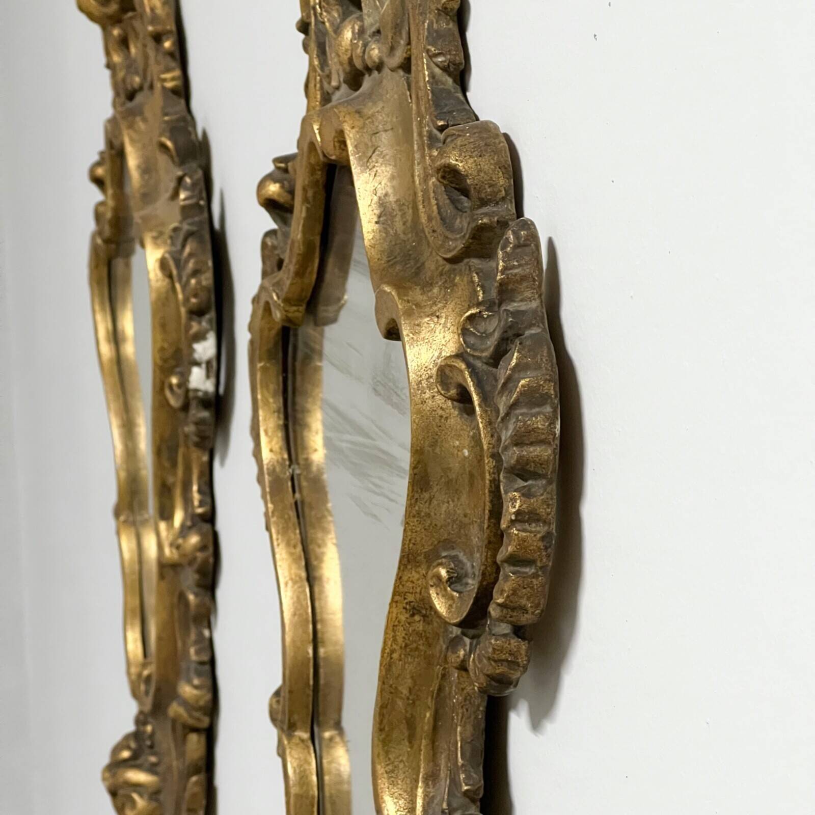 Pair of mirrors in wood decorated with gold leaf.