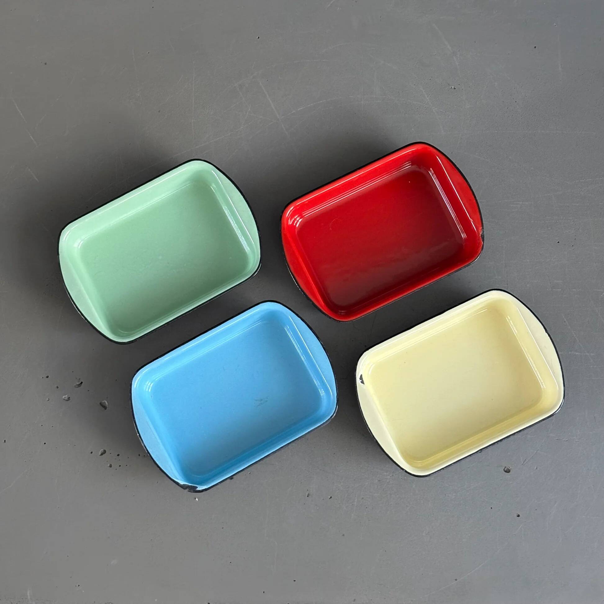 Set of 4 enamelled cast iron dishes/platters.