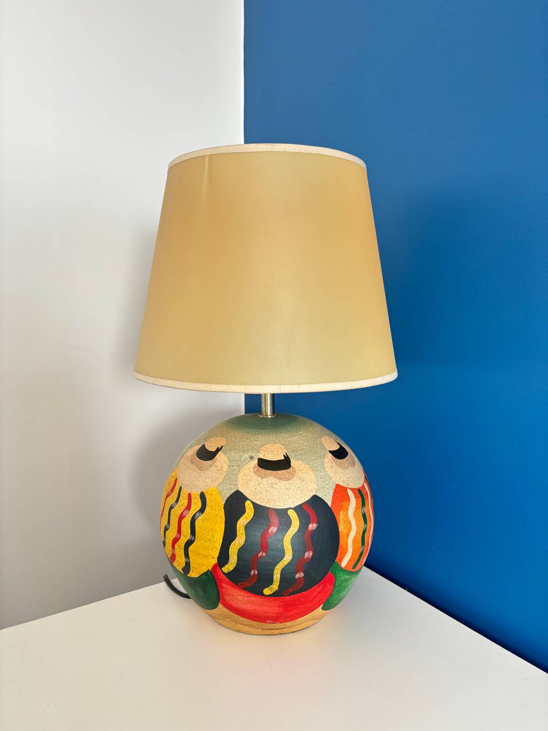 Ceramic table lamp representing women in hats on the sand.