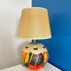 Ceramic table lamp representing women in hats on the sand.