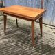 Table vintage portefeuille en chêne aux pieds compas.