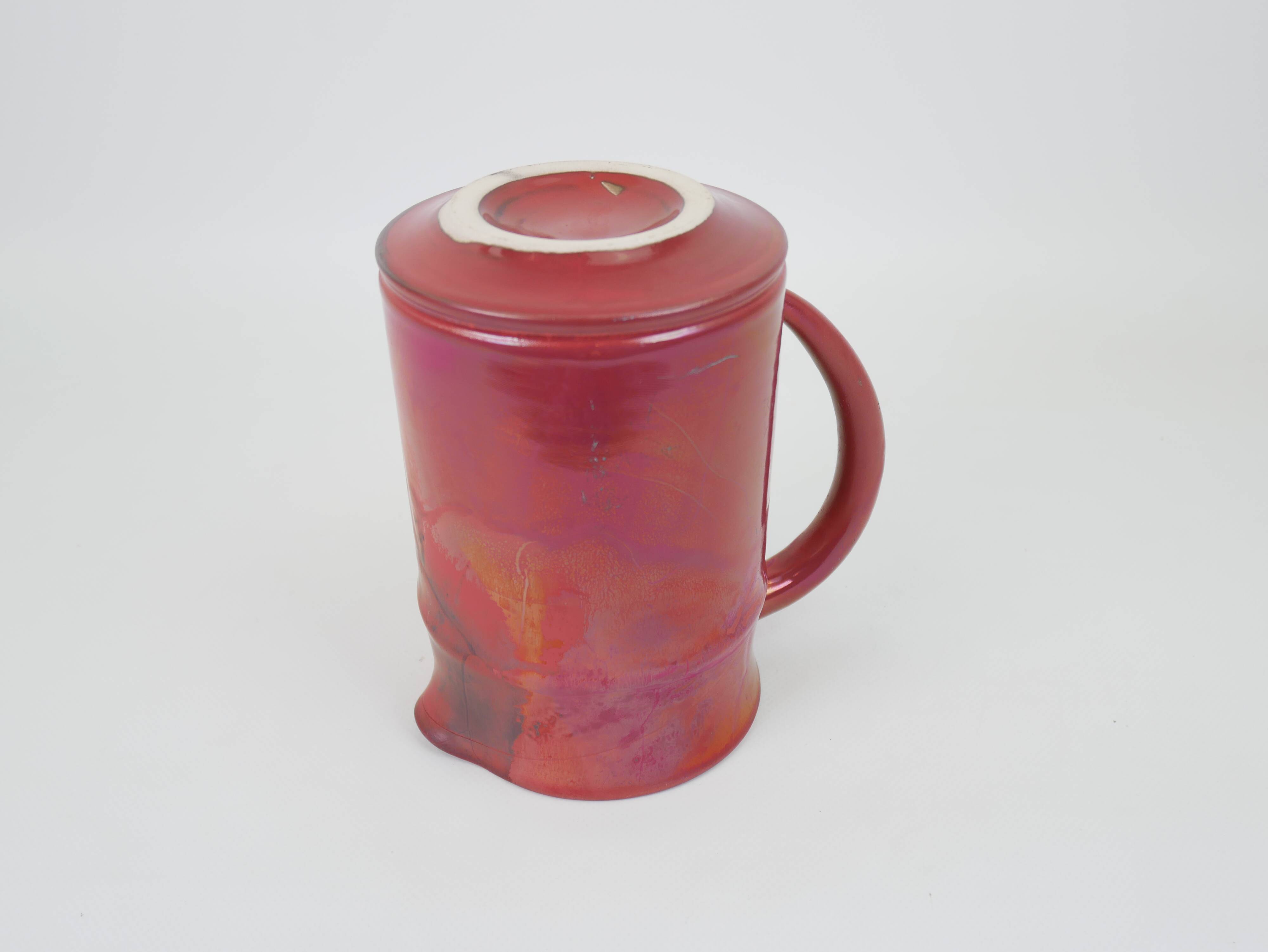 Red glazed ceramic jug with relief