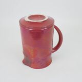 Red glazed ceramic jug with relief