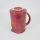 Red glazed ceramic jug with relief