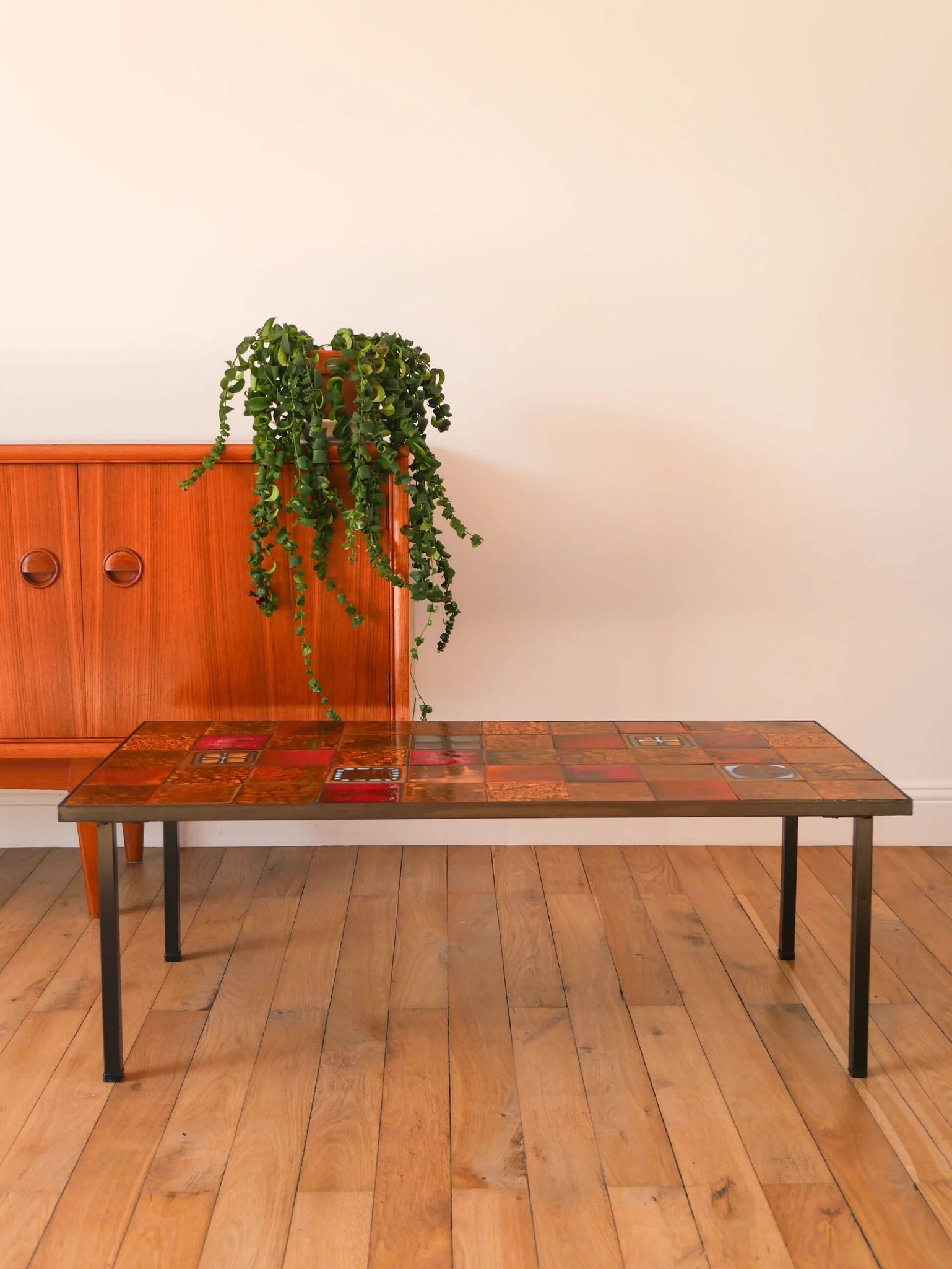 Ceramic and black iron coffee table, attributed to the Roche-Bobois brand, with a black metal base and structure, rectangular ceramic top from Vallauris with colourful patterns in ochre and orange, design from the 1970s.