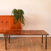 Ceramic and black iron coffee table, attributed to the Roche-Bobois brand, with a black metal base and structure, rectangular ceramic top from Vallauris with colourful patterns in ochre and orange, design from the 1970s.