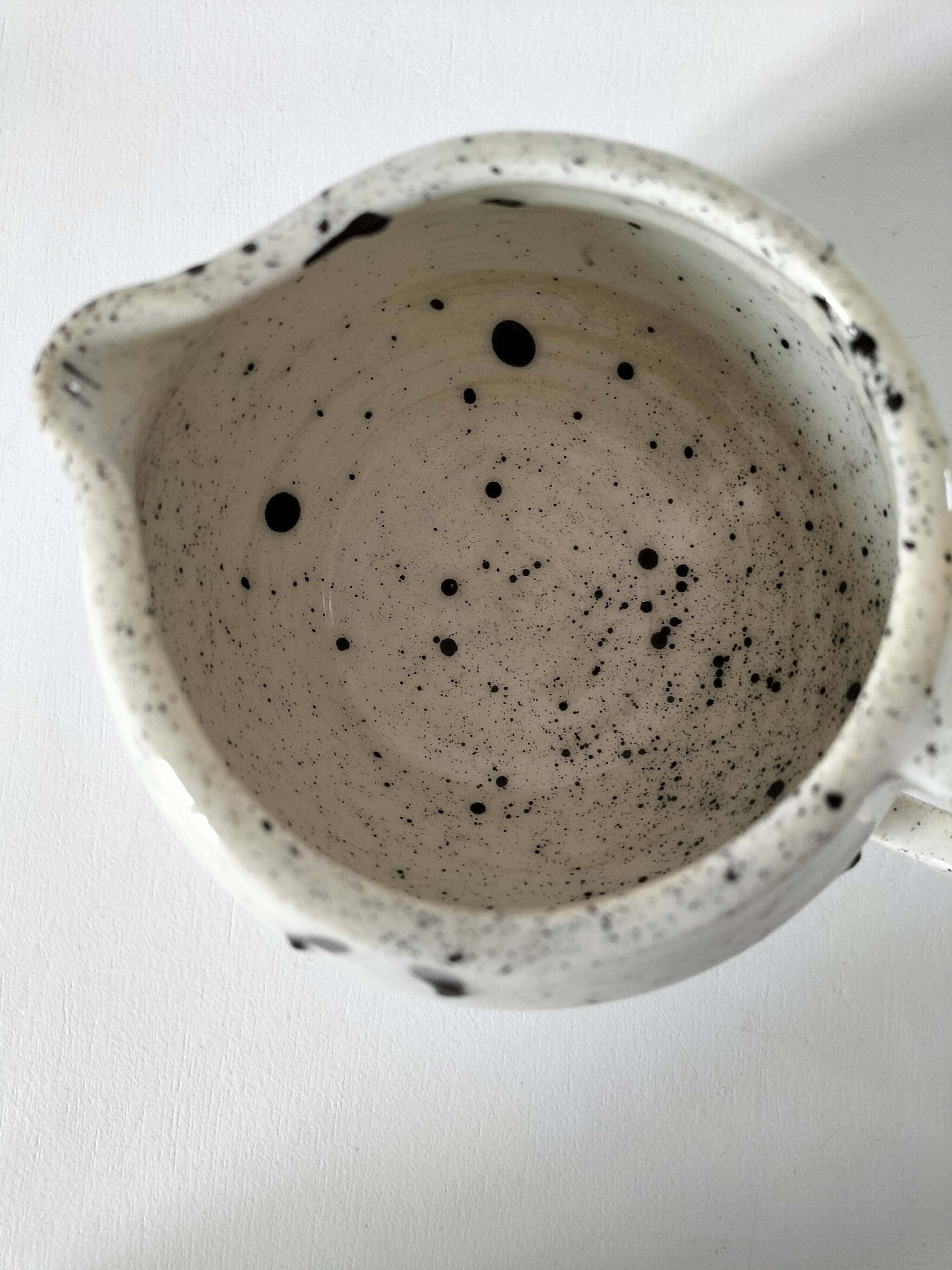 Small speckled ceramic jug in a vintage workshop style.