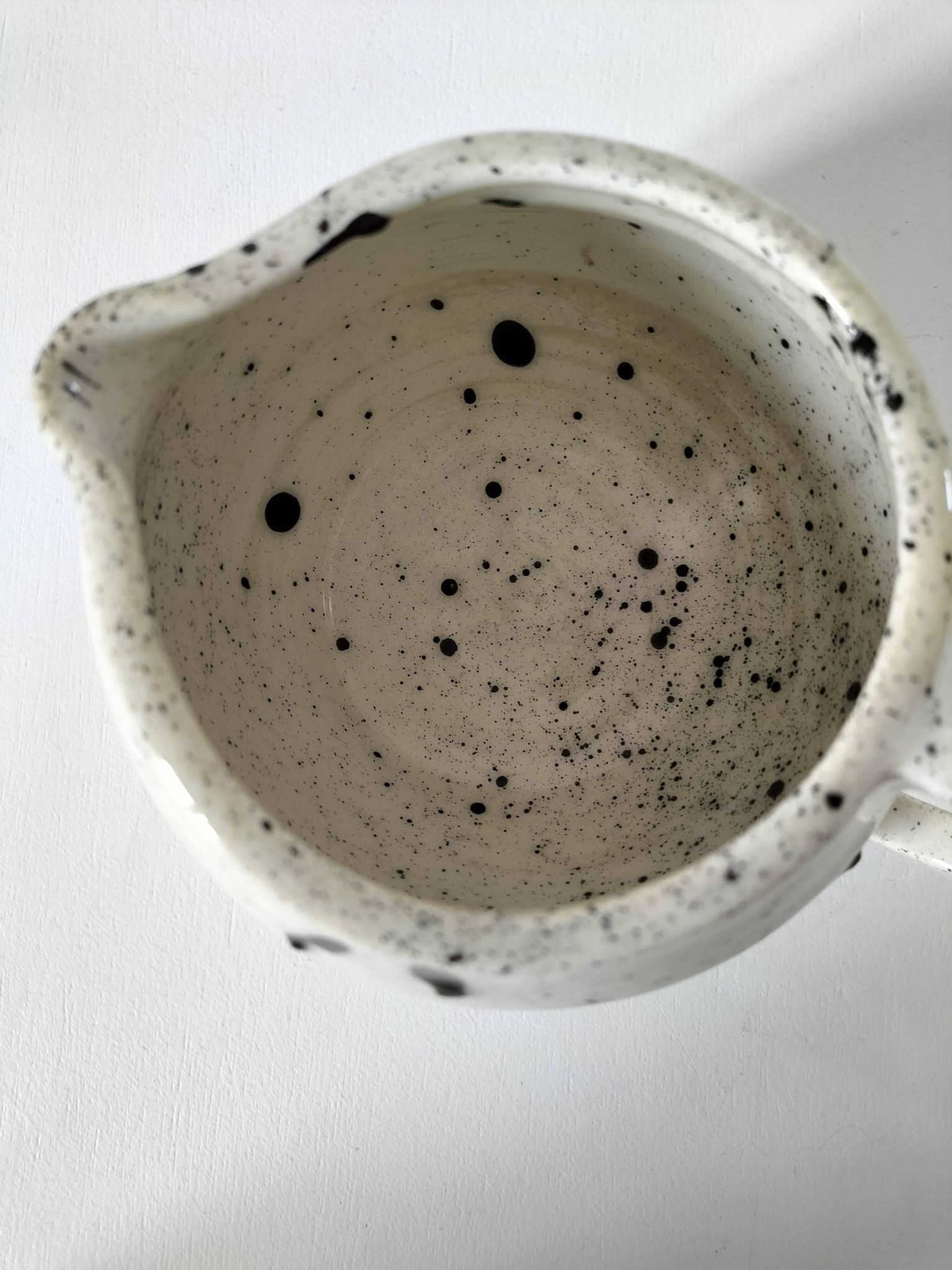 Small speckled ceramic jug in a vintage workshop style.