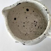Small speckled ceramic jug in a vintage workshop style.