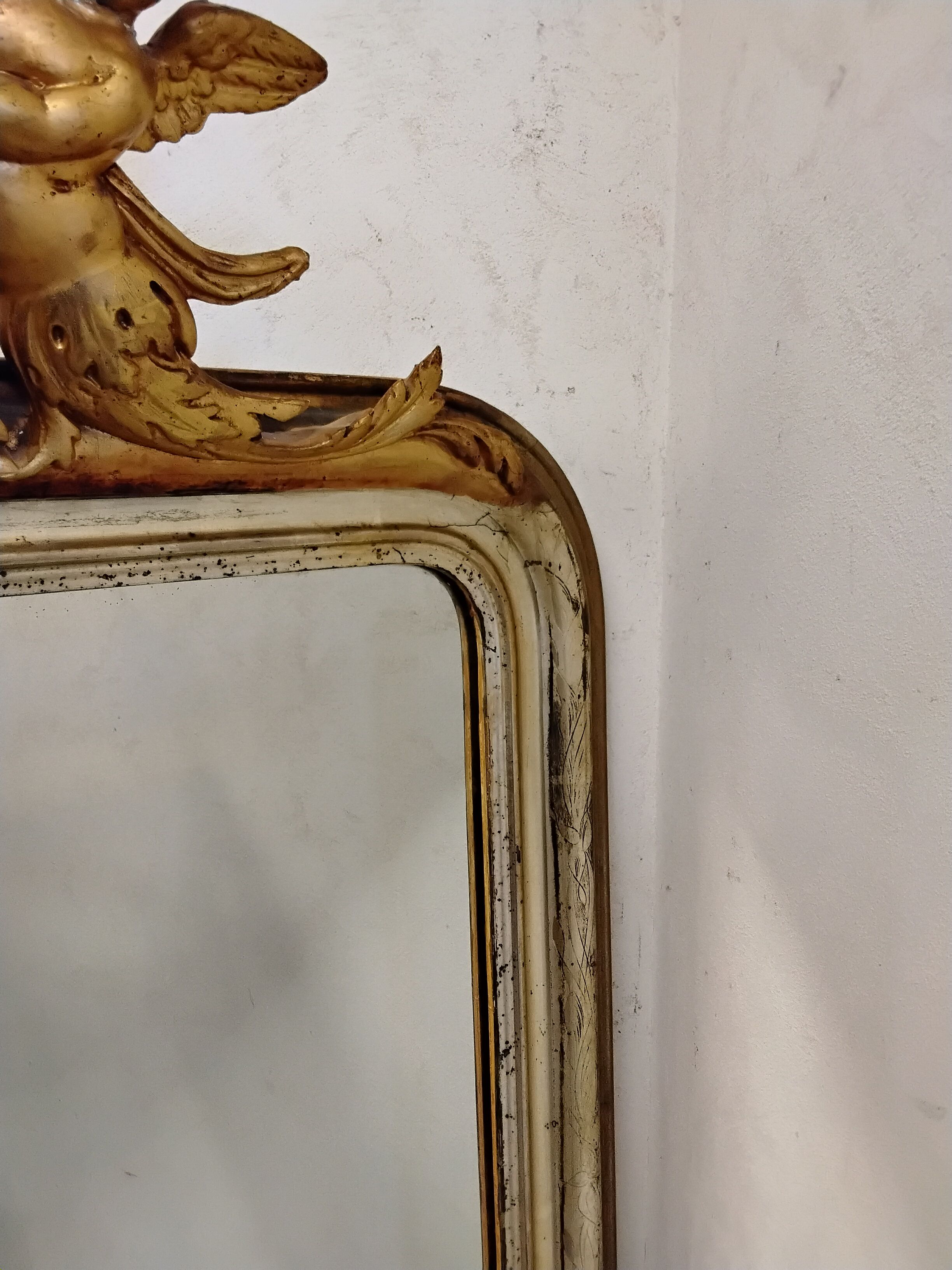 Antique mirror with a gilded frame and cherubs.