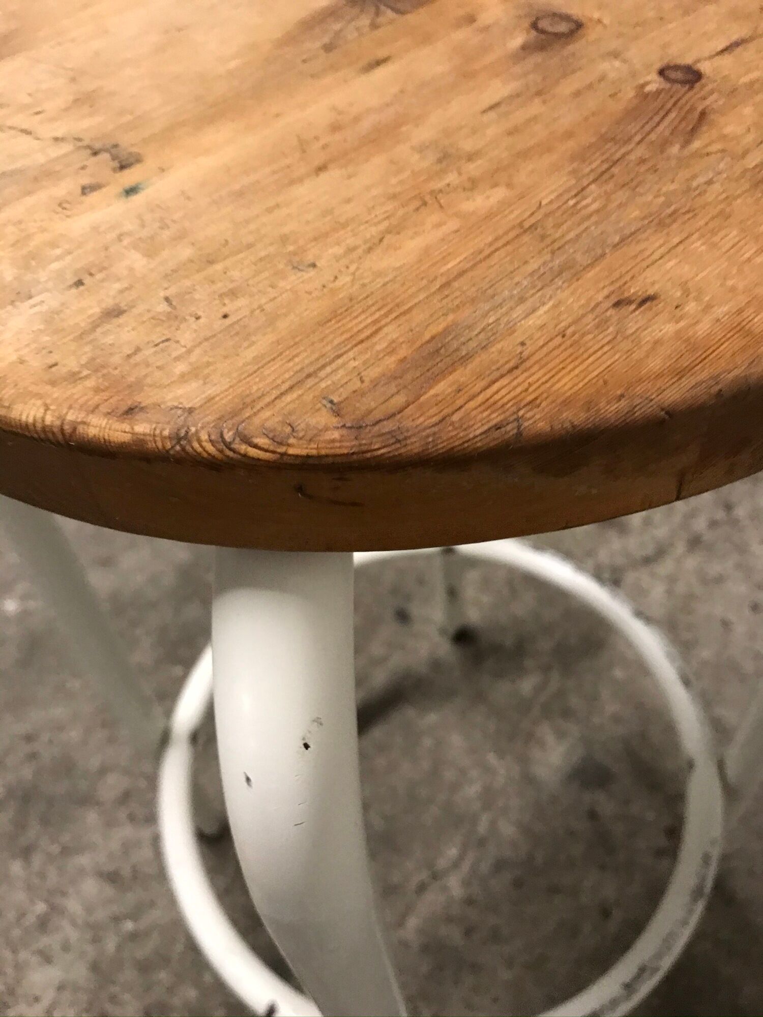 Vintage bar stool in white lace-up, round wooden seat rests circular feet