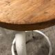 Vintage bar stool in white lace-up, round wooden seat rests circular feet