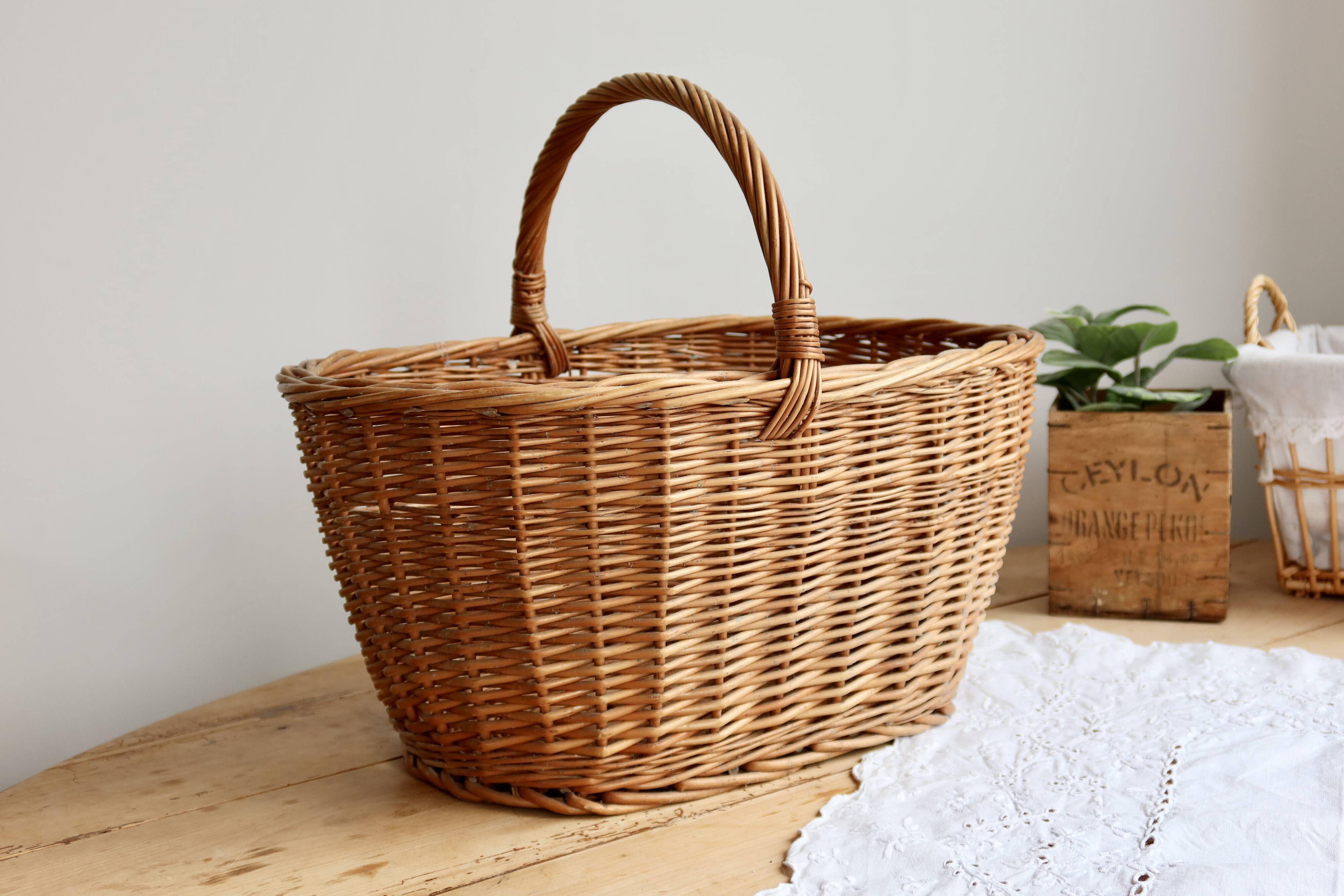 Large vintage woven wicker basket with a central handle.