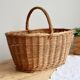 Large vintage woven wicker basket with a central handle.