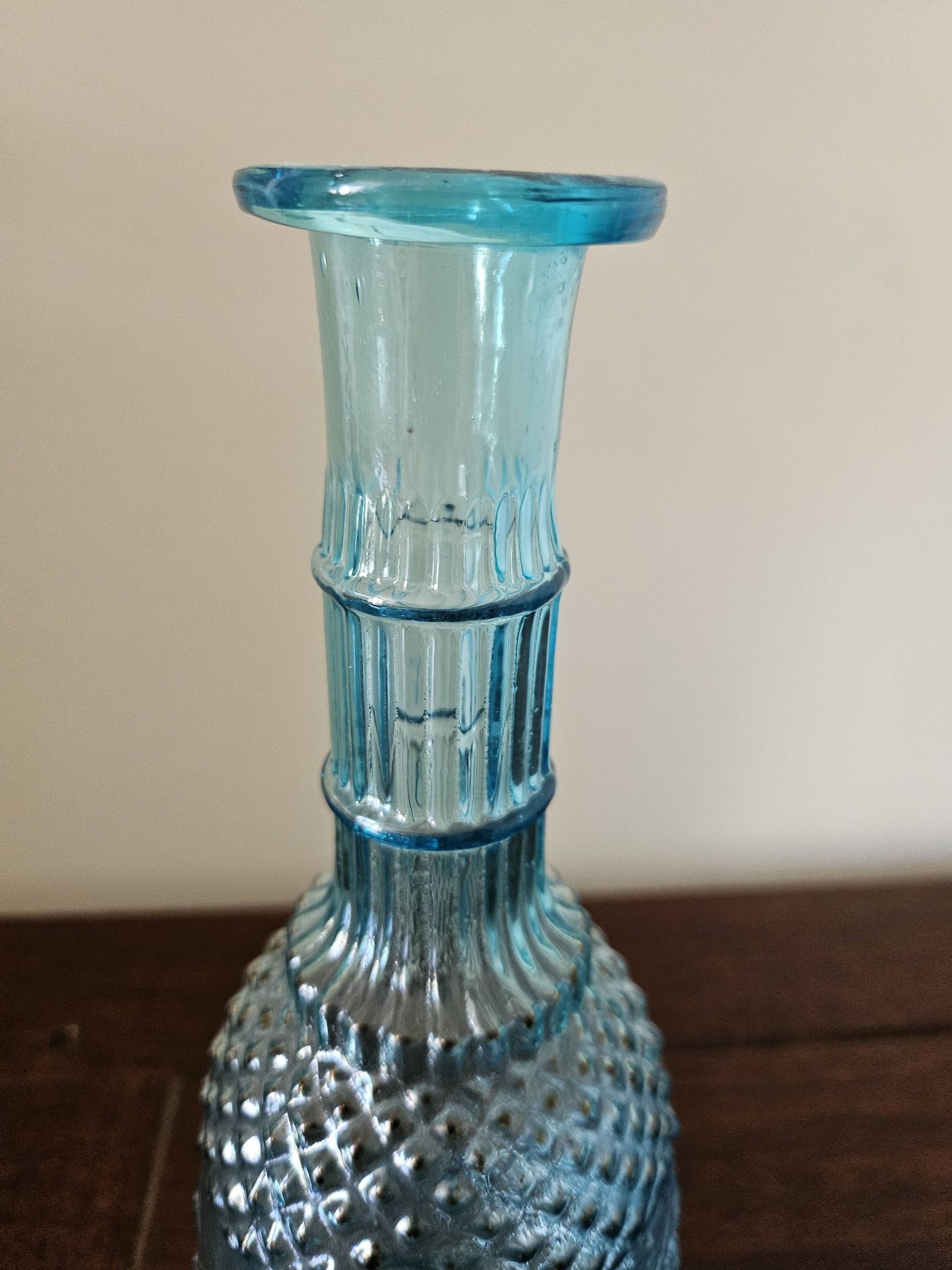 Small vintage turquoise blue glass carafe with floral design.