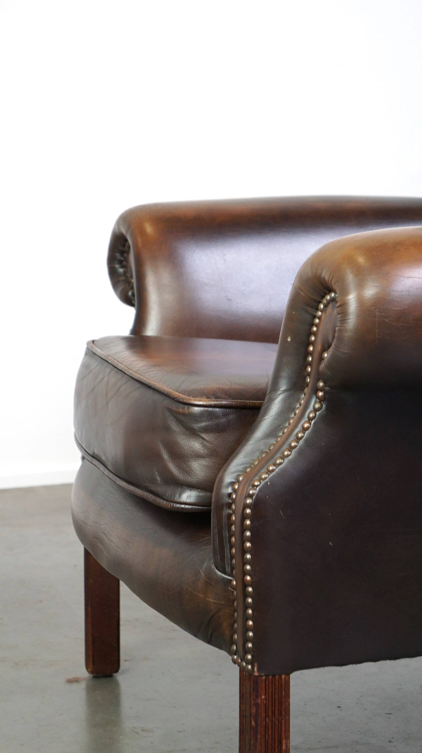 Chesterfield wing chair in dark brown leather with a luxurious appearance