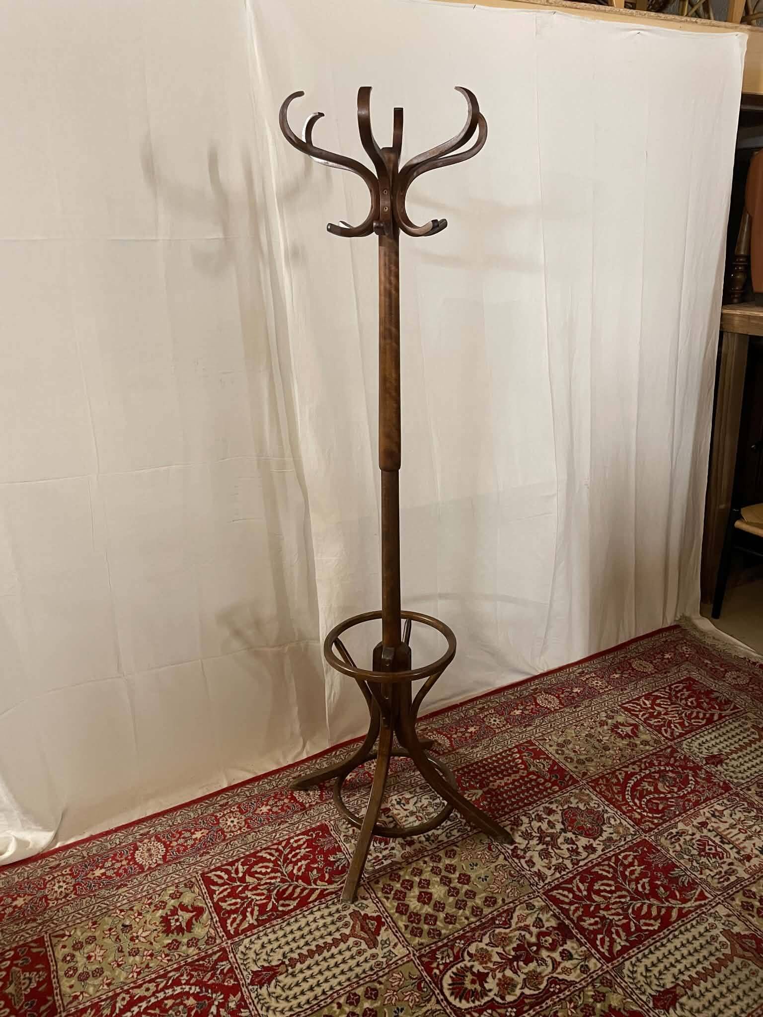 Antique curved wooden coat rack with umbrella stand.