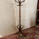 Antique curved wooden coat rack with umbrella stand.