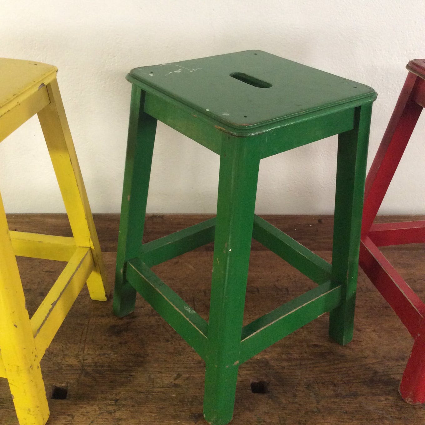 Three wooden stools with a handle