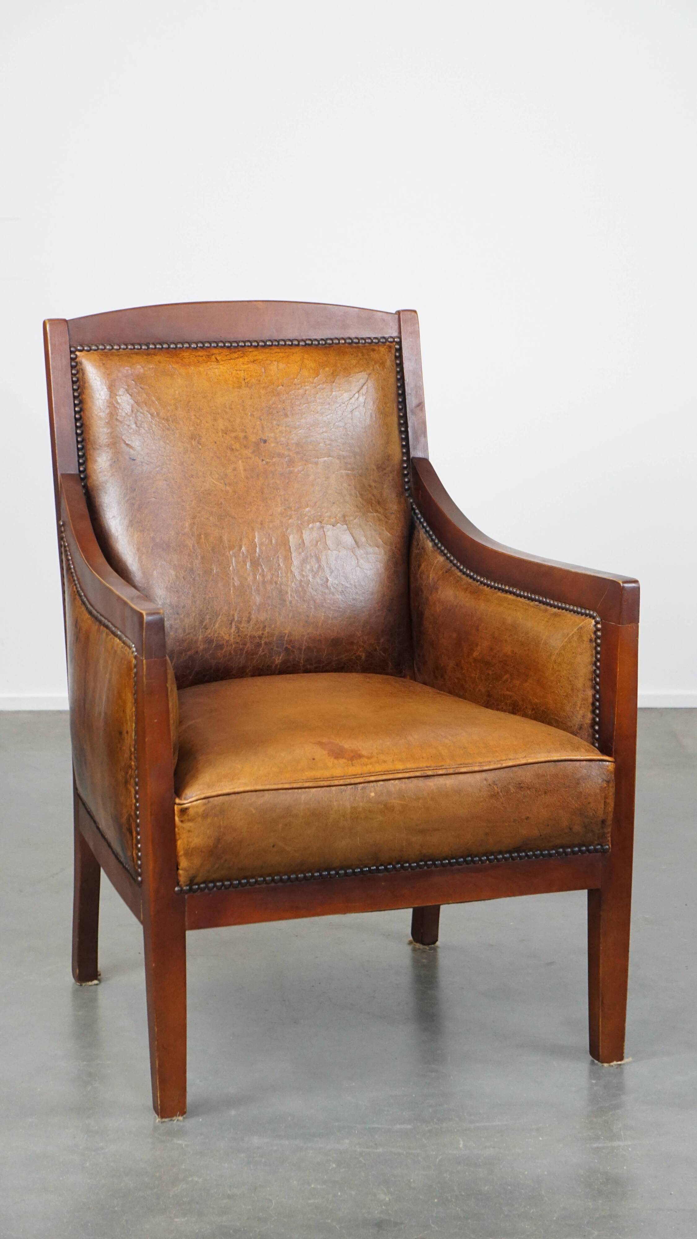 Sheepskin and wooden vintage Art Deco design armchair in a cognac color