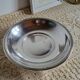 Shallow round metal plate with pearl bead decoration.