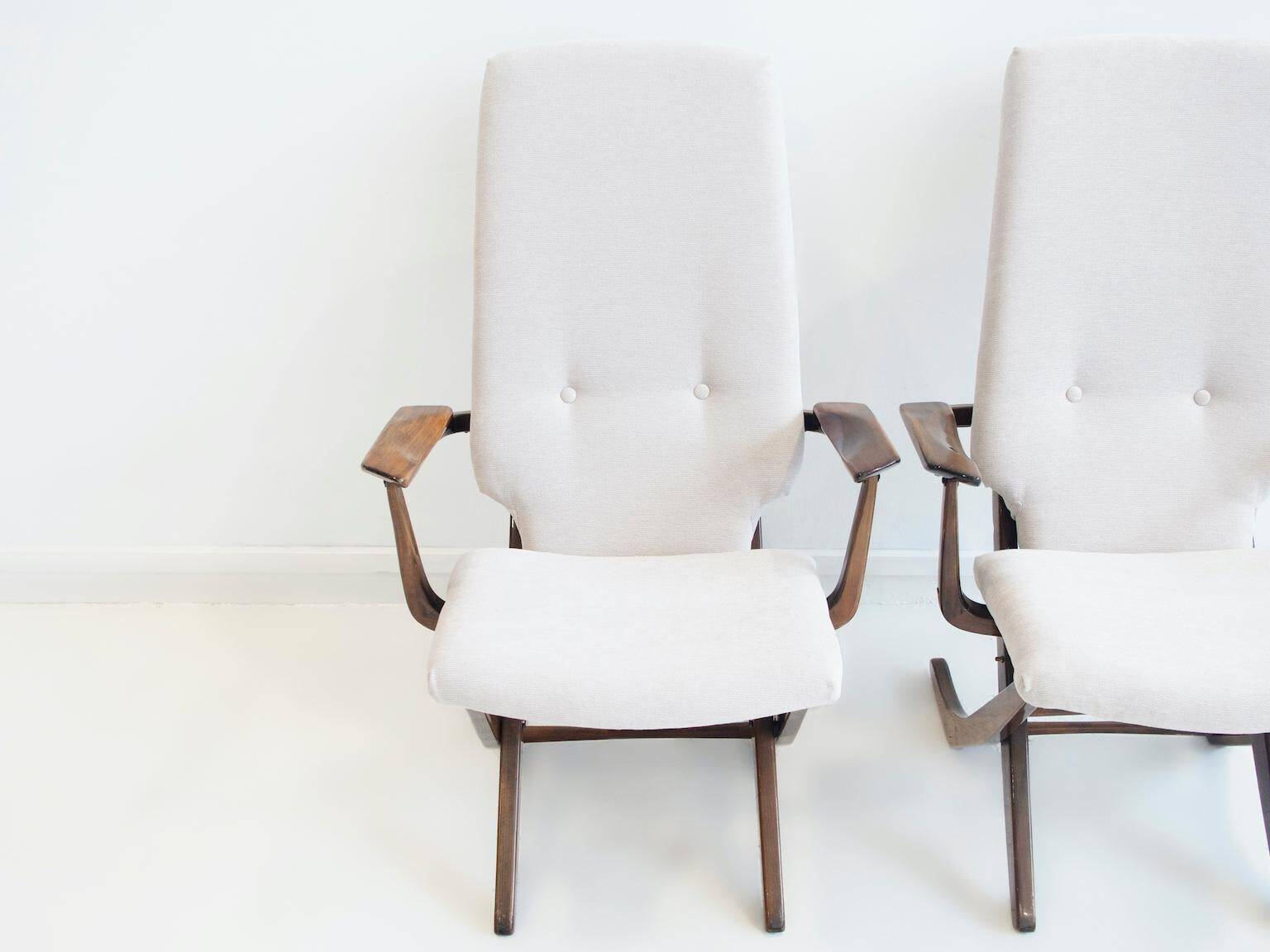 Pair of varnished wooden reclining armchairs, upholstered in lightweight fabric.