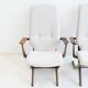 Pair of varnished wooden reclining armchairs, upholstered in lightweight fabric.