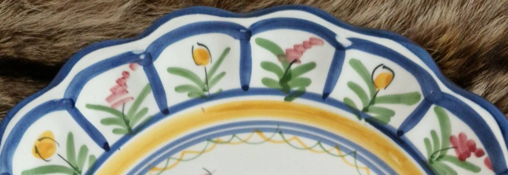 Large hand-painted French faience plate with floral decoration in folk art style.