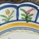 Large hand-painted French faience plate with floral decoration in folk art style.