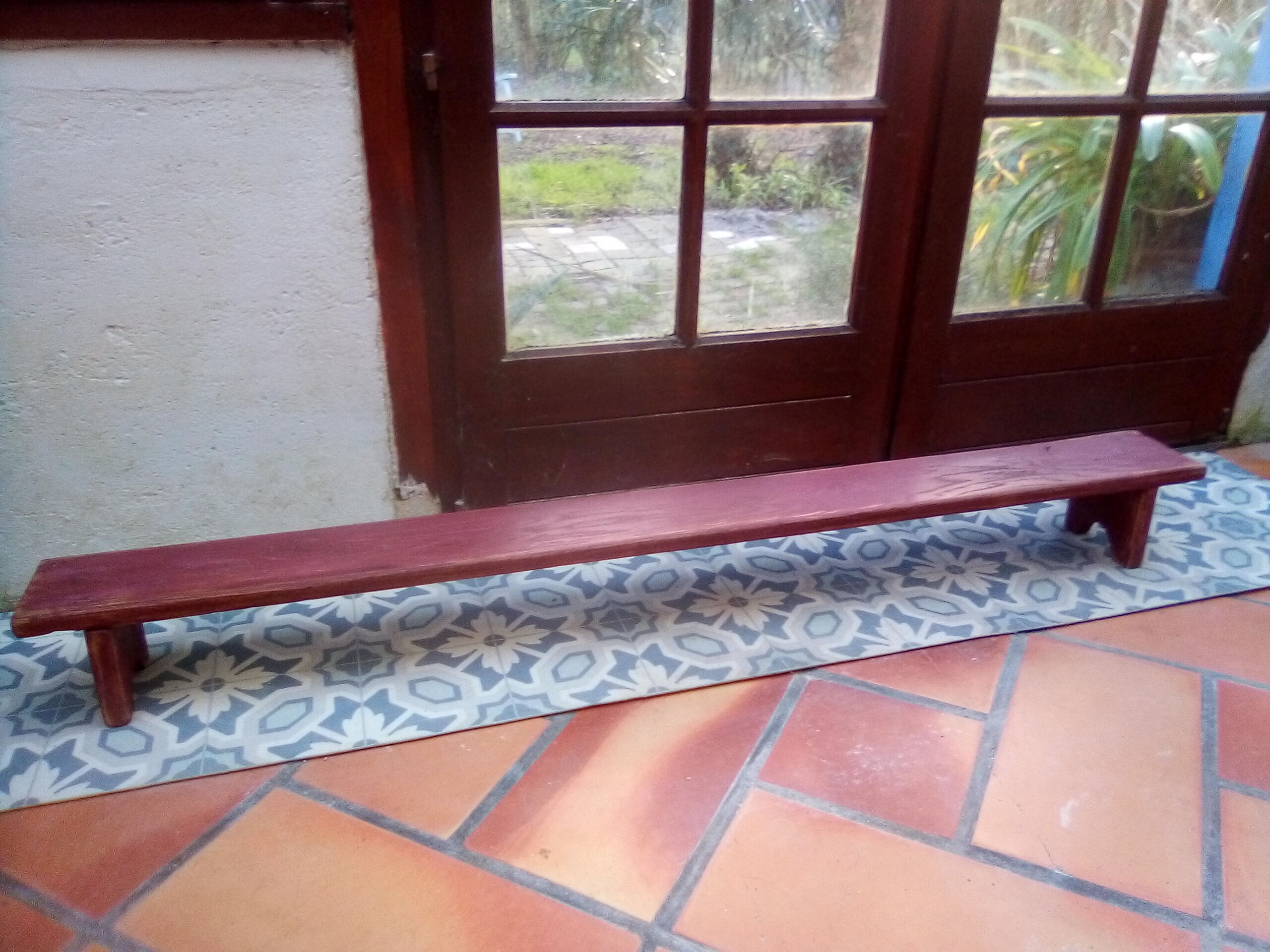 Low bench rests feet in patinated wood