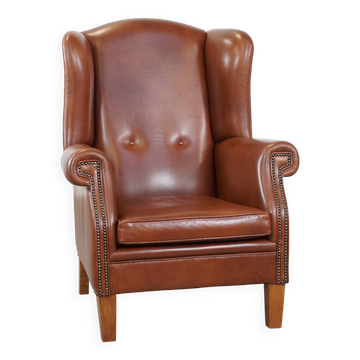 Cognac-colored leather wingback chair in English style