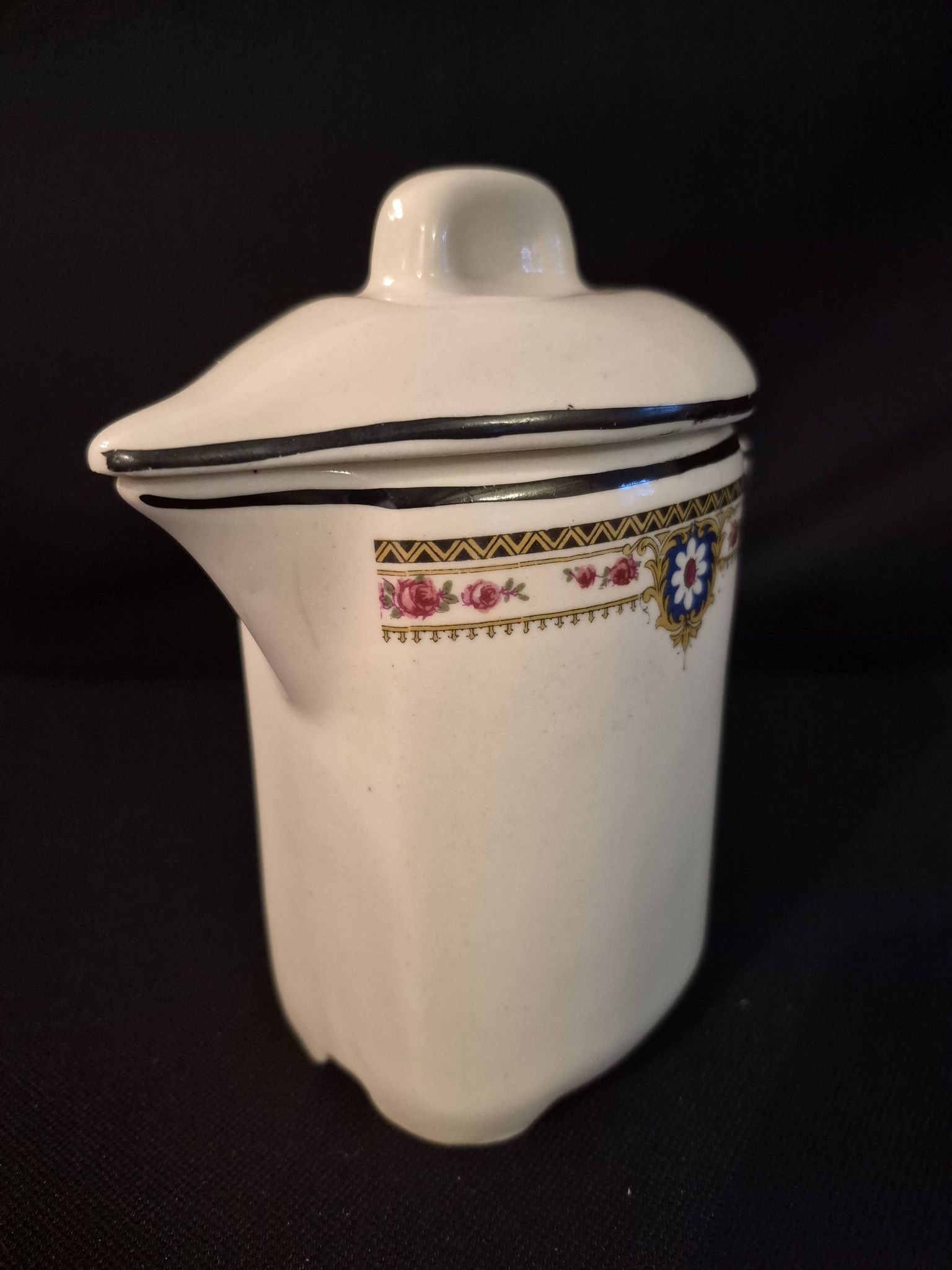 Vintage vase, geometric frieze and flowers with a black border.