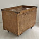 Old large wicker laundry basket on wheels
