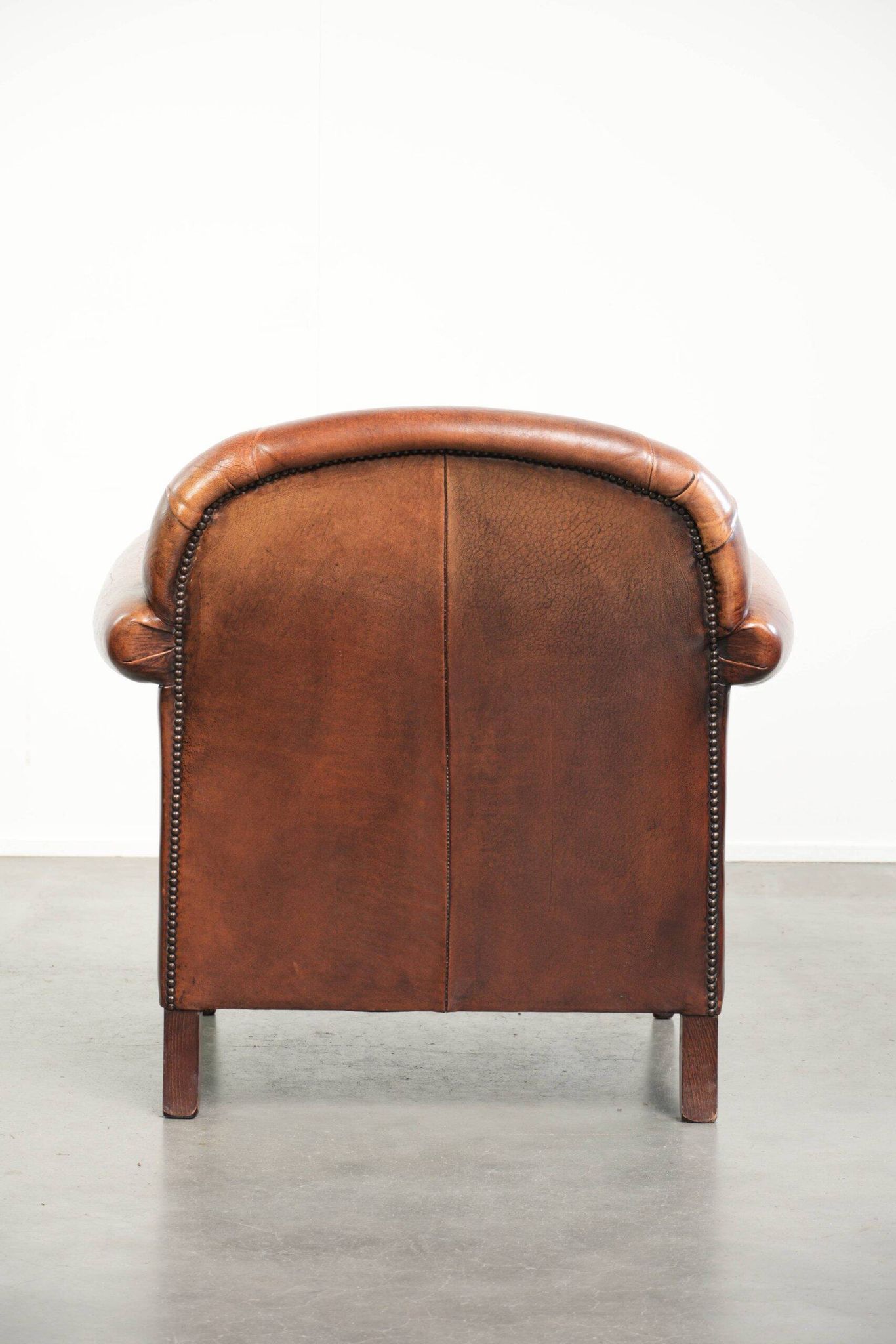 Comfortable vintage sheepskin armchair finished with decorative nails