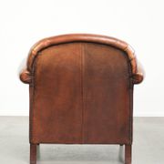 Comfortable vintage sheepskin armchair finished with decorative nails