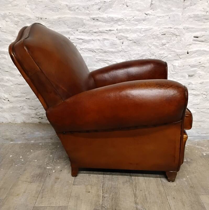 Antique club chair with gendarme hat back