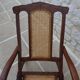 Antique folding chair with caned seat and backrest made of wood.